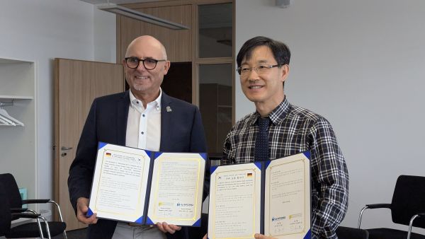 Schulleiter Sigi Zistler und sein Amtskollege Song Hyun Jin unterzeichnen die Absichtserklärung zur Zusammenarbeit.
