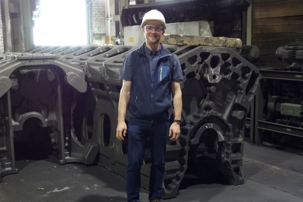 Lehrkraft Michael Geiger vor dem Kurbelgehäuse eines Großmotors